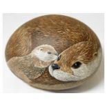 A hand painted large pebble depicting otter & cub