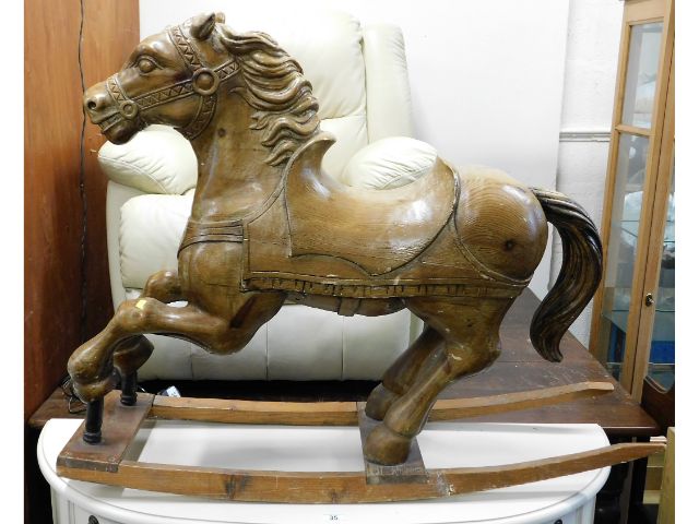 An antique pitch pine carved galloping pony, belie