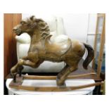 An antique pitch pine carved galloping pony, belie