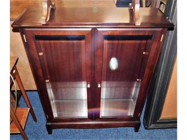 A modern mahogany display cabinet with glass shelv