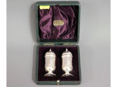 A cased pair of Edwardian 1902 silver pepper pots,