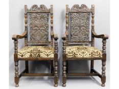 A pair of upholstered matching heavily carved oak