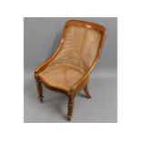 An early 19thC. period walnut Bergere style cane library chair with tapering reeded legs to front &