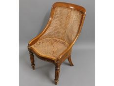 An early 19thC. period walnut Bergere style cane library chair with tapering reeded legs to front &