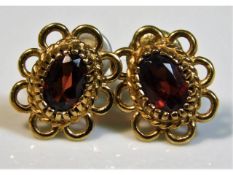A pair of 9ct gold earrings set with garnets, 1.6g