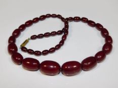 A vintage 24in long cherry amber style beaded necklace, 52.2g, largest bead 1in wide