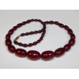 A vintage 24in long cherry amber style beaded necklace, 52.2g, largest bead 1in wide