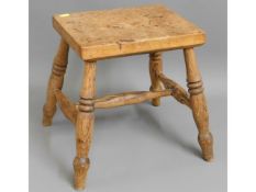 An early 20thC. oak stool with turned legs, 13.75in high