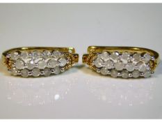 A pair of 10ct gold earrings set with approx. 1ct