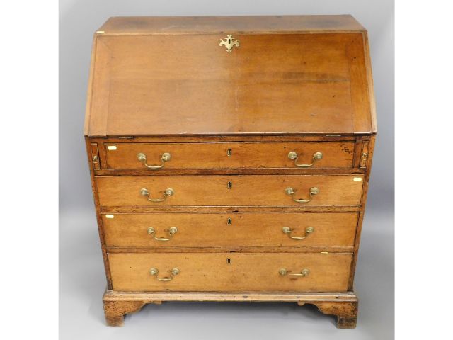 An 18thC. Georgian oak bureau with ogee feet & bra