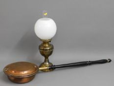 A copper bed warmer twinned with a brass oil lamp