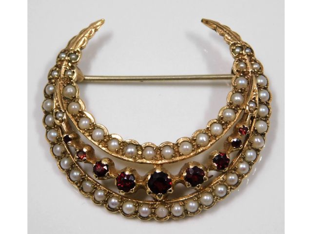 A 9ct gold crescent shaped brooch set with seed pe