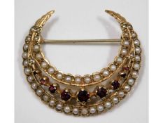 A 9ct gold crescent shaped brooch set with seed pe