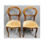 A pair of upholstered balloon backed chairs