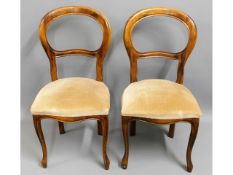 A pair of upholstered balloon backed chairs