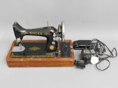 A cased Singer electric sewing machine