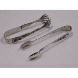 A white metal set of tongs with dragon decor, test