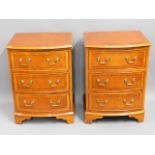 A pair of bow fronted bedside cabinets with brass