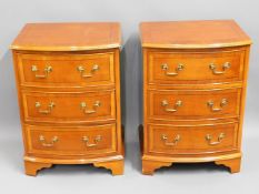 A pair of bow fronted bedside cabinets with brass