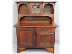 An arts & crafts stained oak dresser with leaded g