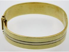 A two colour, 9ct gold bangle with clasp, internal diameter 60.25mm, 28.2g