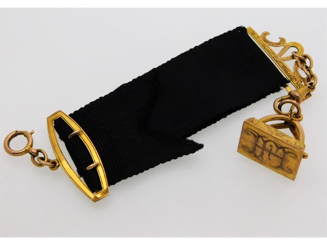 A 9ct gold mounted mourning ribbon with 9ct fob, 8