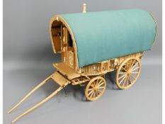 A large model of a gypsy caravan requiring painting, furnished inside with accessories, 31.5in long