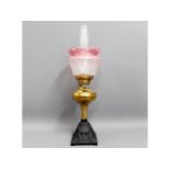 A Victorian brass oil lamp with cast iron base & c