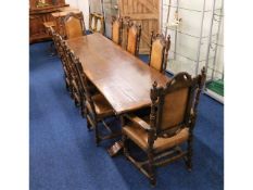 A substantial oak trestle table with six leather u