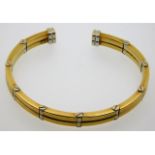 An 18ct two colour gold flexi bangle, internal mea