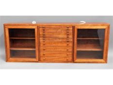 A craftsman built teak collectors cabinet with gla