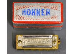 A Hohner miniature mouth organ & original box, 38m