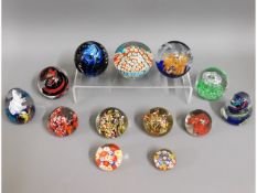 A quantity of 13 glass paper weights including