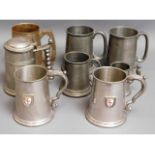 A pair of pewter tankards with enamelled badges tw