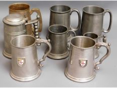 A pair of pewter tankards with enamelled badges tw