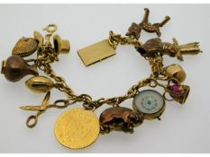 An 18ct gold charm bracelet set with 16 charms, ni