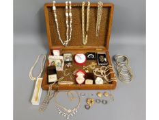 An oak case containing a quantity of costume jewel