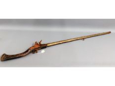 A 19thC. middle eastern flint lock rifle, 56in lon