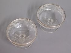 A pair of antique cut glass bonbons set with silve