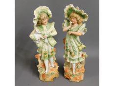 A pair of continental bisque porcelain figures, 13.125in tall, chip to top of hat on girl figure