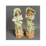 A pair of continental bisque porcelain figures, 13.125in tall, chip to top of hat on girl figure