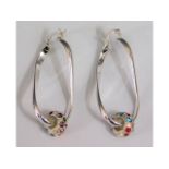 A pair of decorative silver drop earrings