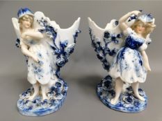 A pair of German Sitzendorf porcelain ornamental spills, one with repair to arm, 7in tall £30-40