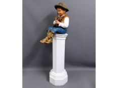 A possibly early 20thC. heavy plaster model of boy playing brass flute sat on later painted wooden p