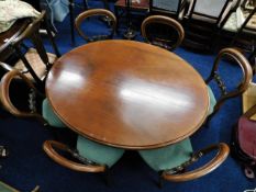 A Victorian mahogany tilt top oval breakfast table with six stained walnut balloon back chairs, 53in