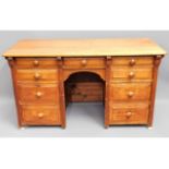 An antique light oak knee hole desk with nine draw