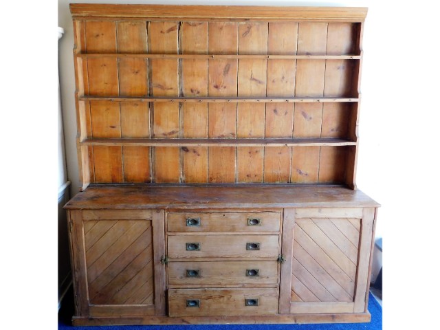 A large antique pitch pine dresser with two cupboa