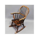 A 19thC. child's elm seated rocking chair, 25in hi