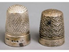 A hallmarked silver thimble twinned with another m