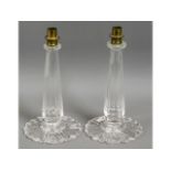 A pair of cut glass candle holder bases with brass
